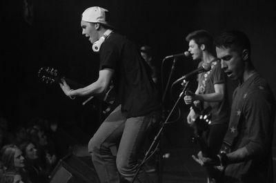 band members of Paper Planes rock out in front of their audience during Battle of the Bands